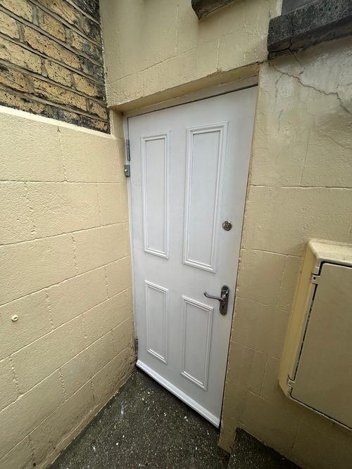 New white external door hung in a blockwork porch, with the frame made good around it