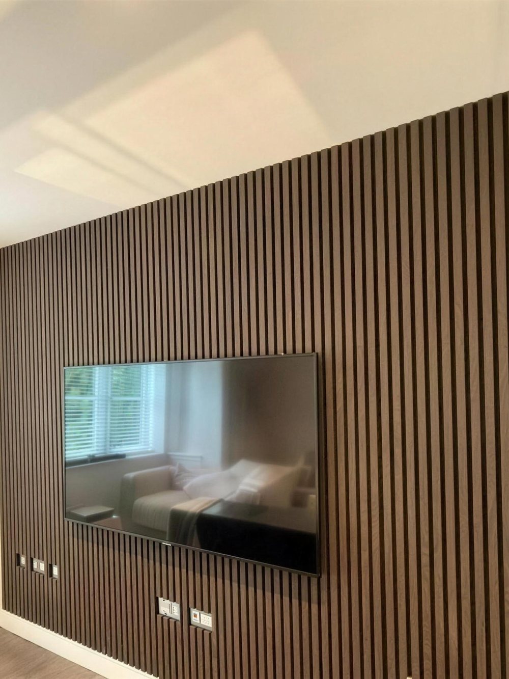 Slat feature wall with a recessed television and inset electric fire, built and fitted by JR Carpentry